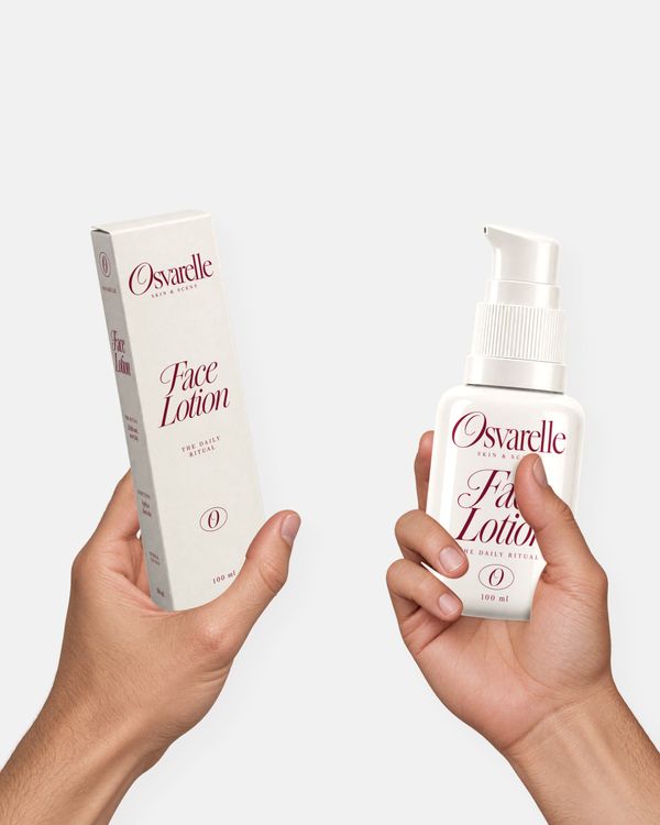 Face lotion bottle and packaging box mockup held in hands against a light gray background.