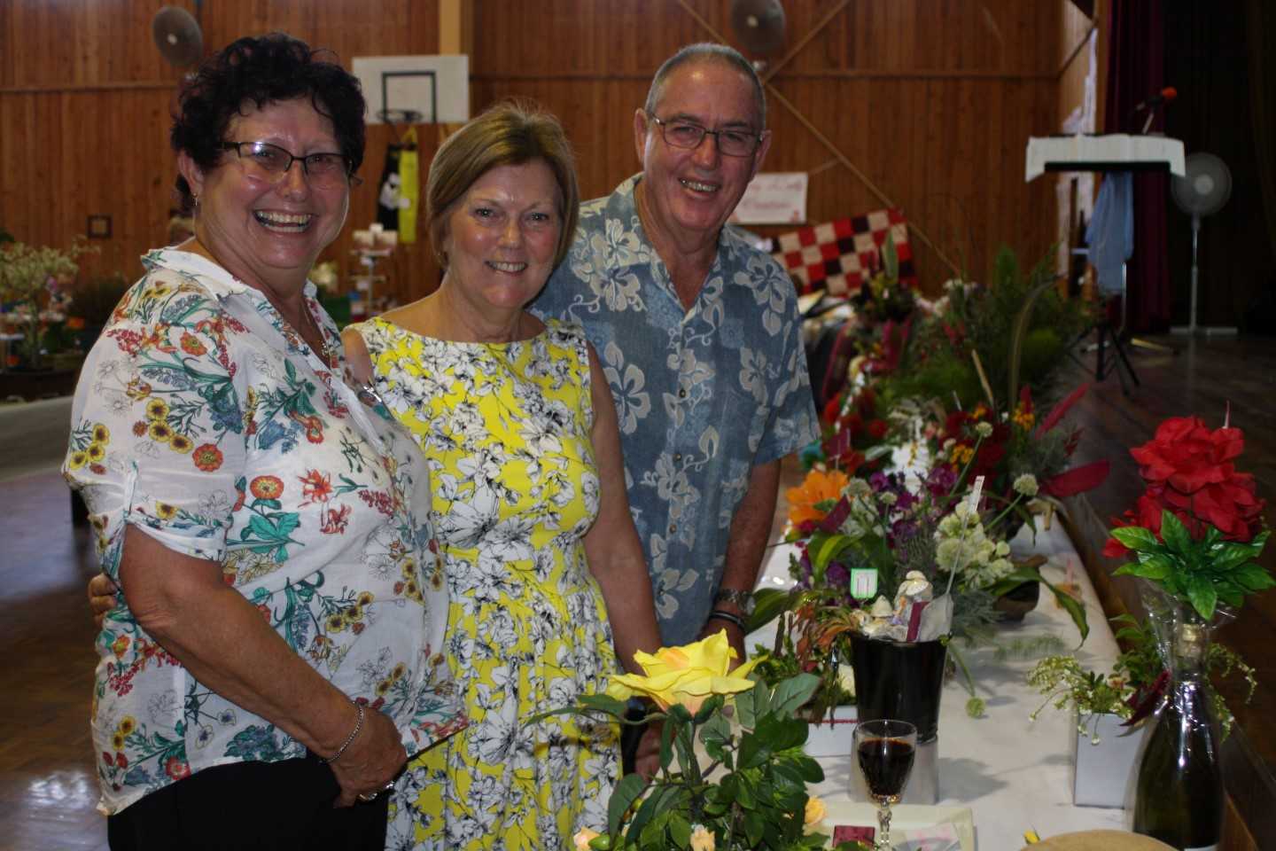 Judy Cantrell, Maree and Phil Heron discuss the themed displays - spotting"Days of Wine and Roses" and the "Yellow Rose of Te