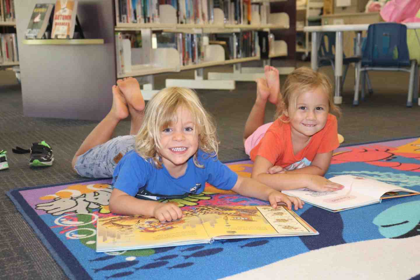 Our libraries have lots on for the school break: Damon and Lelania enjoy a good book at First 5 Forever, Rainbow Beach Librar