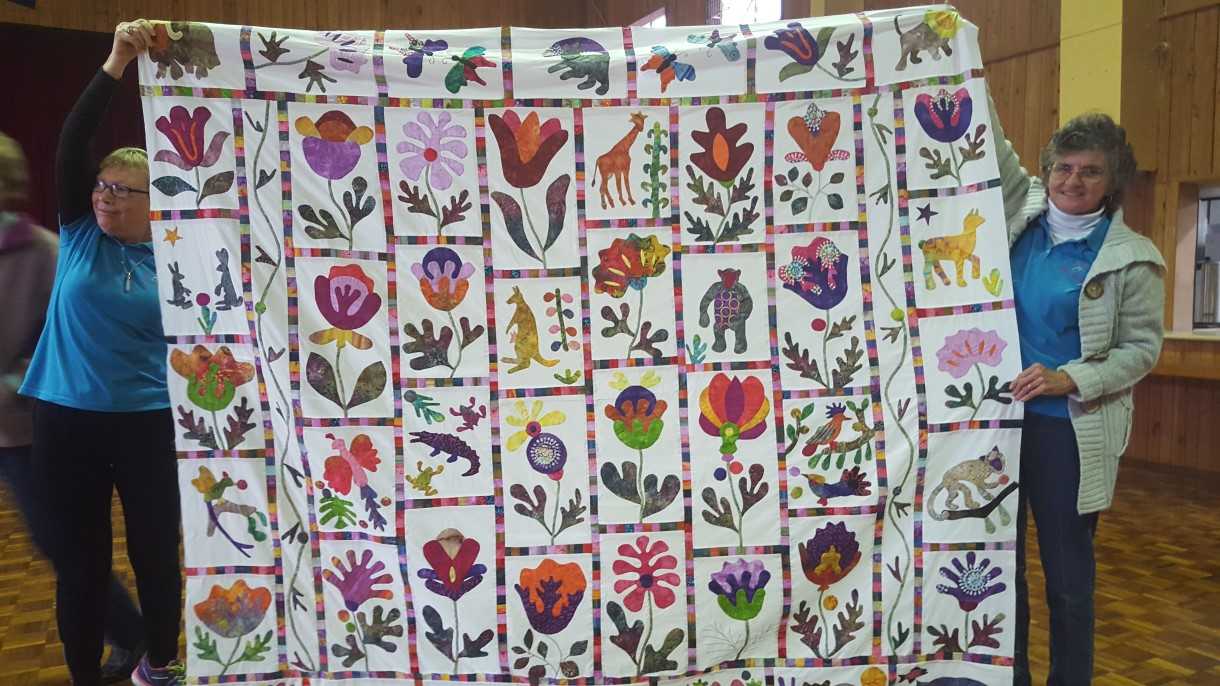 Michelle Mummery helps hold up Beryl Vickery’s (pictured right) beautiful garden quilt