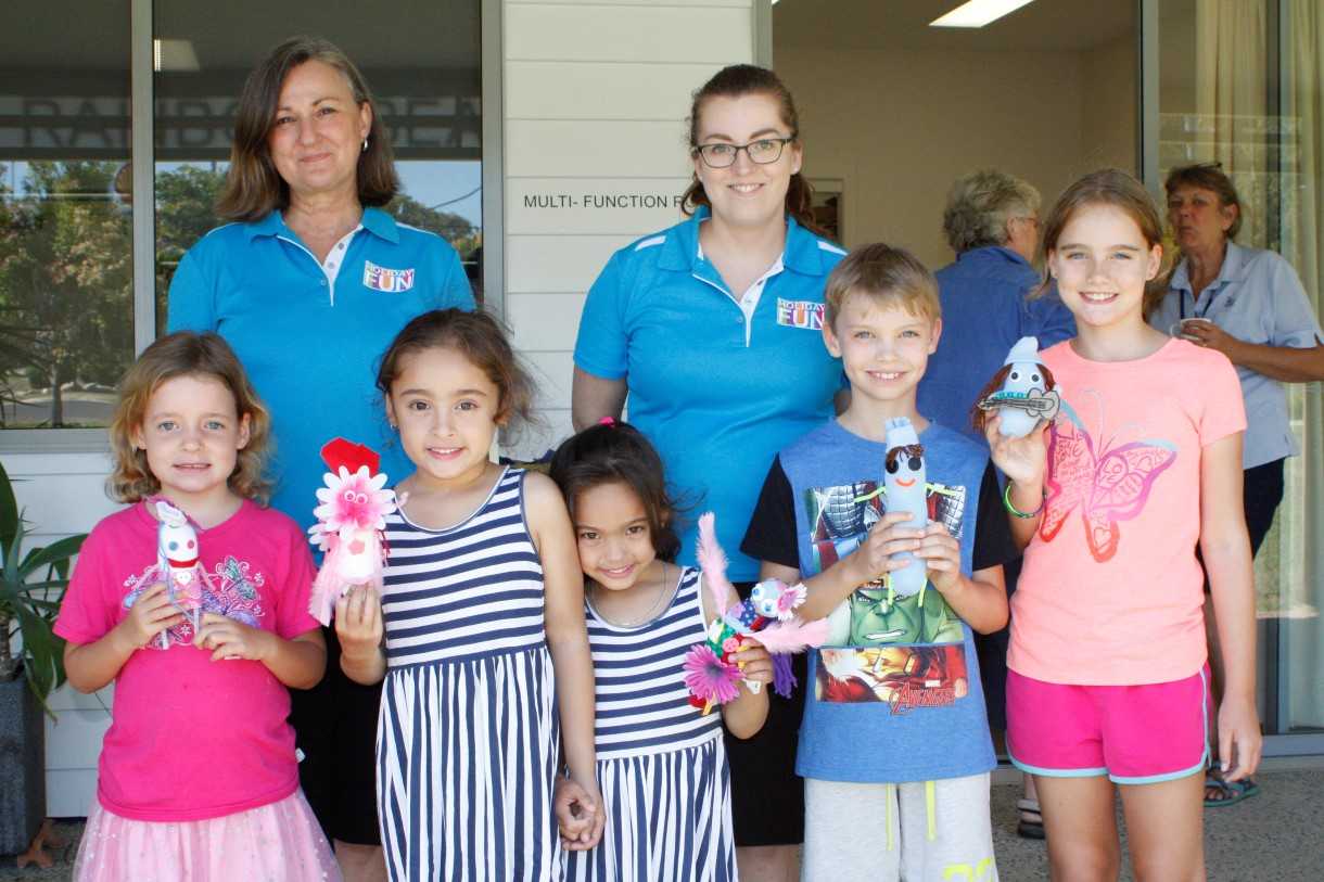 Gympie Regional Libraries team members Jeannette Parke and Rochelle Bull are delighted with the holiday activities sock creations by Elke Morton, Astarlia and Asianna Collins and Sam and Alex Bailey