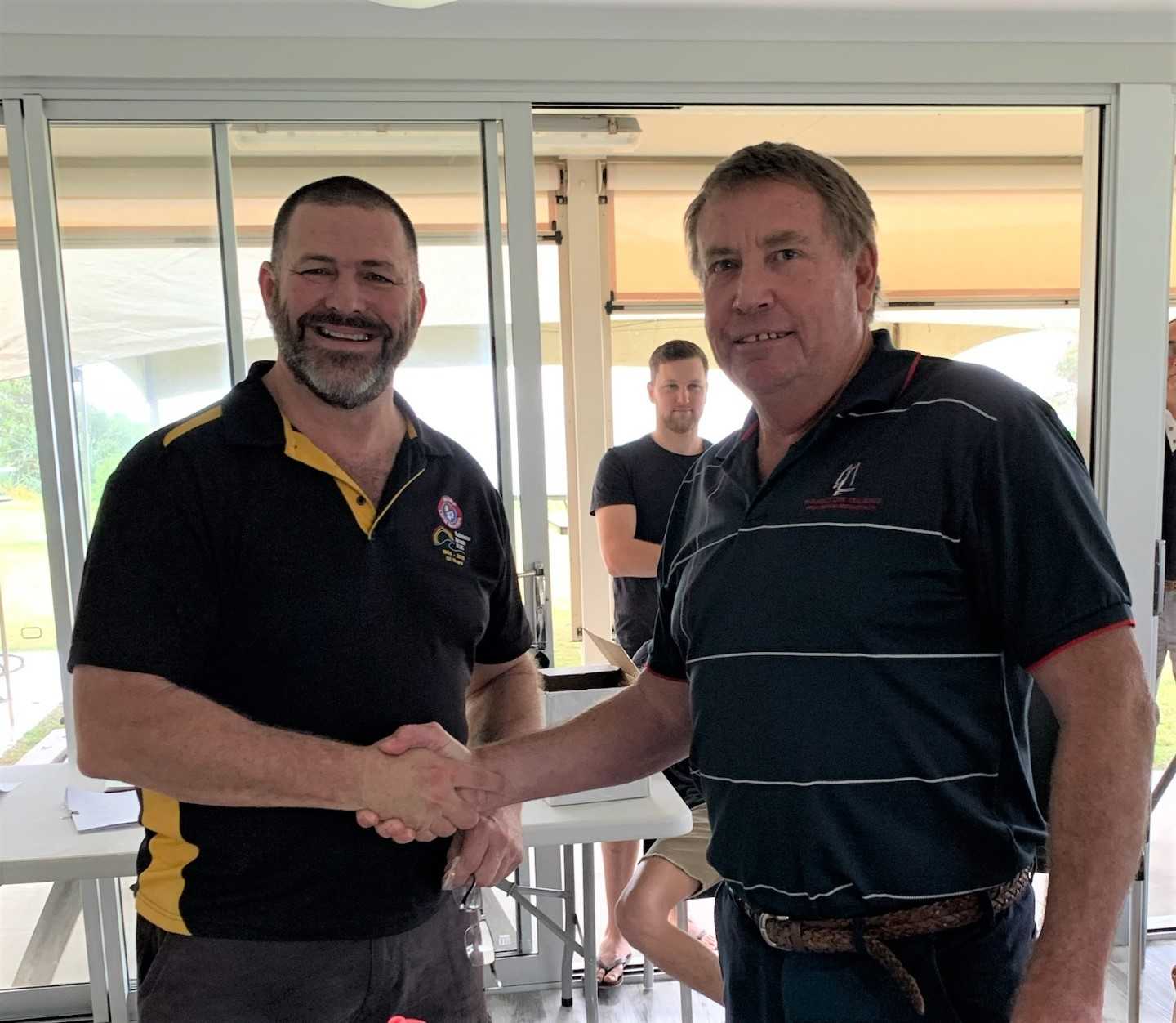 Shane Handy being congratulated by life member Kim McCarthy at the surf club AGM last month after receiving his Life Membership