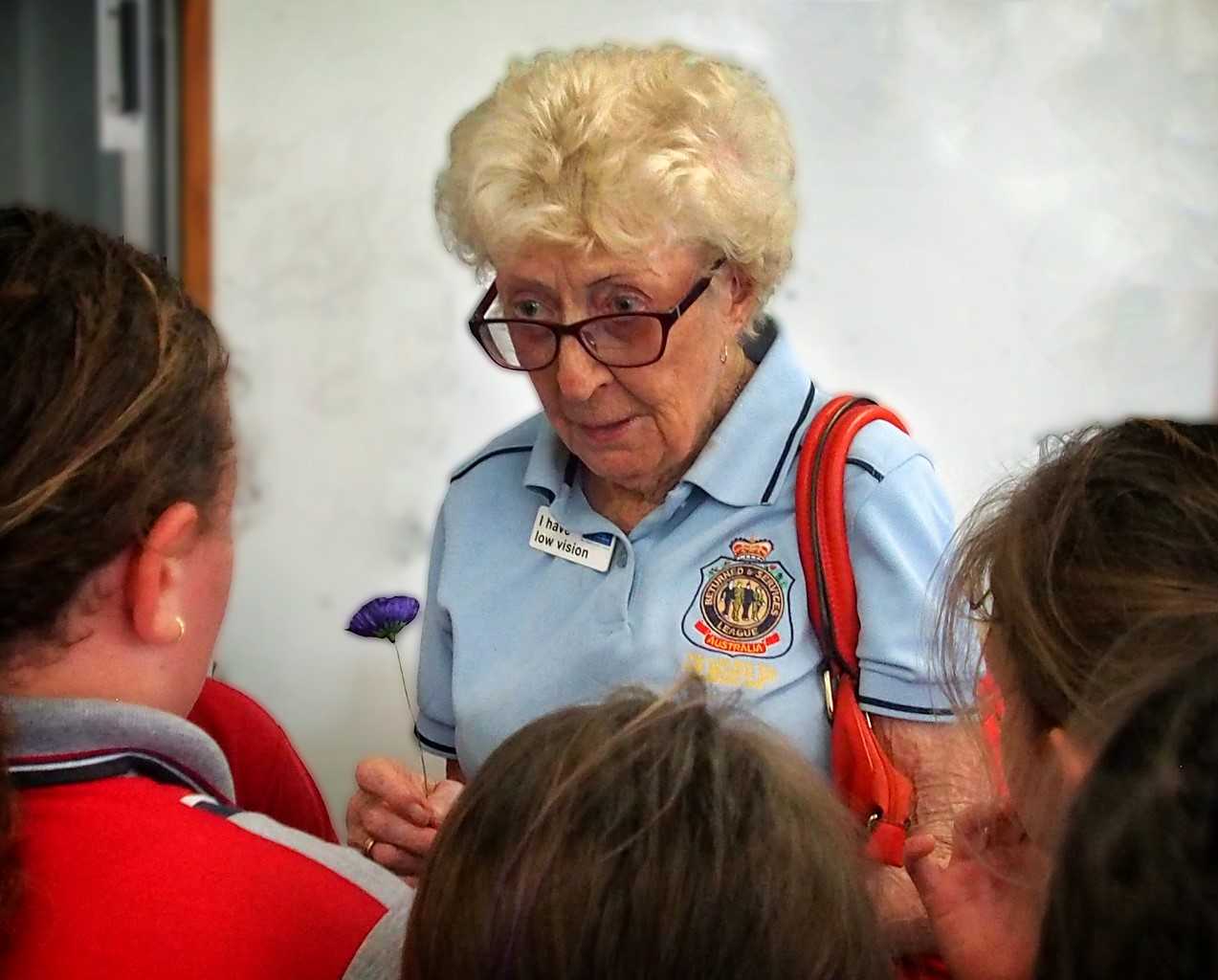 Keeping The Legacy Alive: Melissa Haslam's photo of Pam Leslie, awarded Life Membership of the RSL QLD Branch was taken with Pam surrounded by the school children at one of her many school visits. Not much taller than the children, Pam is explaining the history of the poppy in preparation for Anzac day last year. 