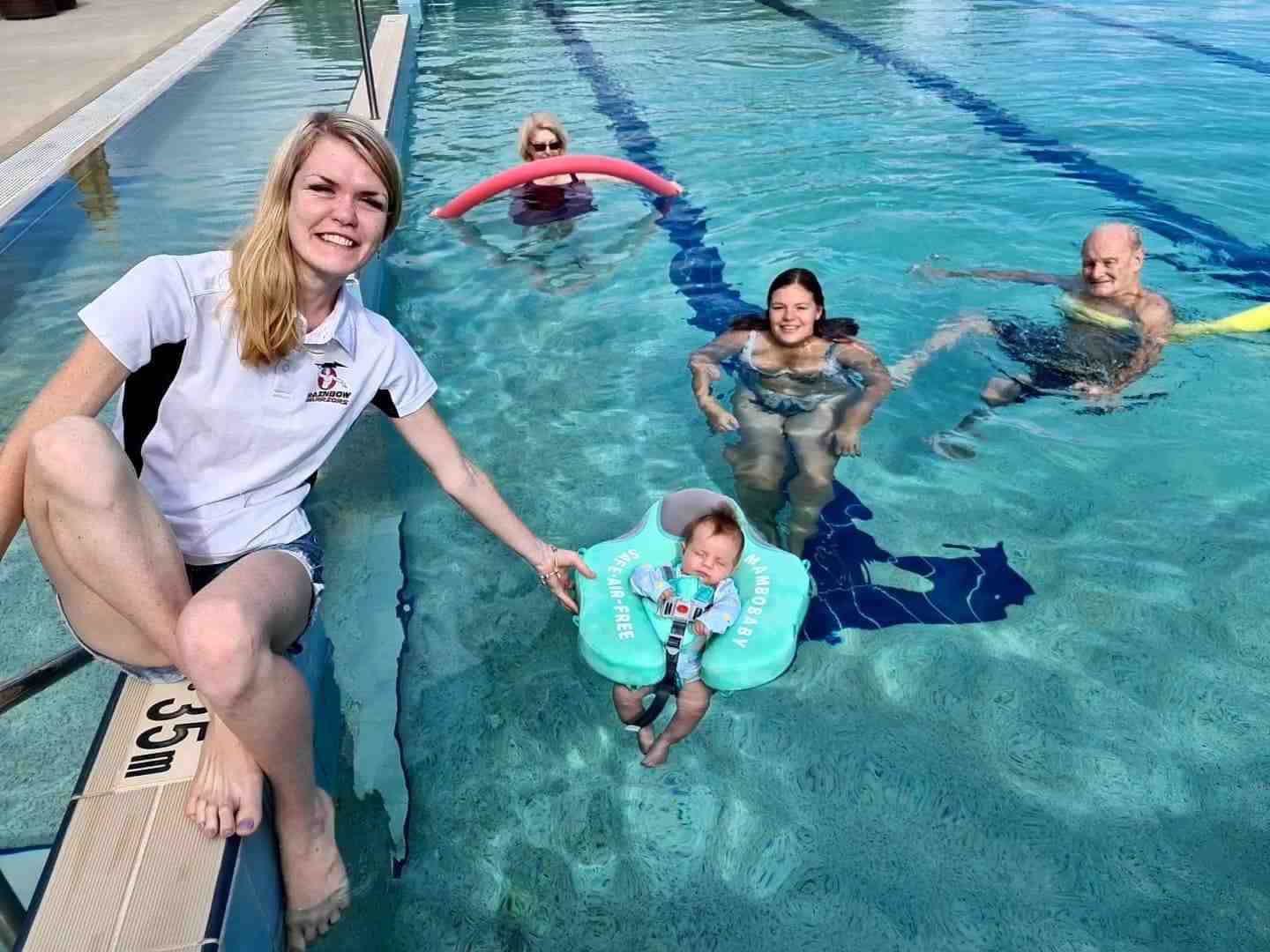 Kyani Parton helping Chris and Bryan Smith and Georgia and baby Banksia get the most of their time in the newly reopened pool at Rainbow Beach