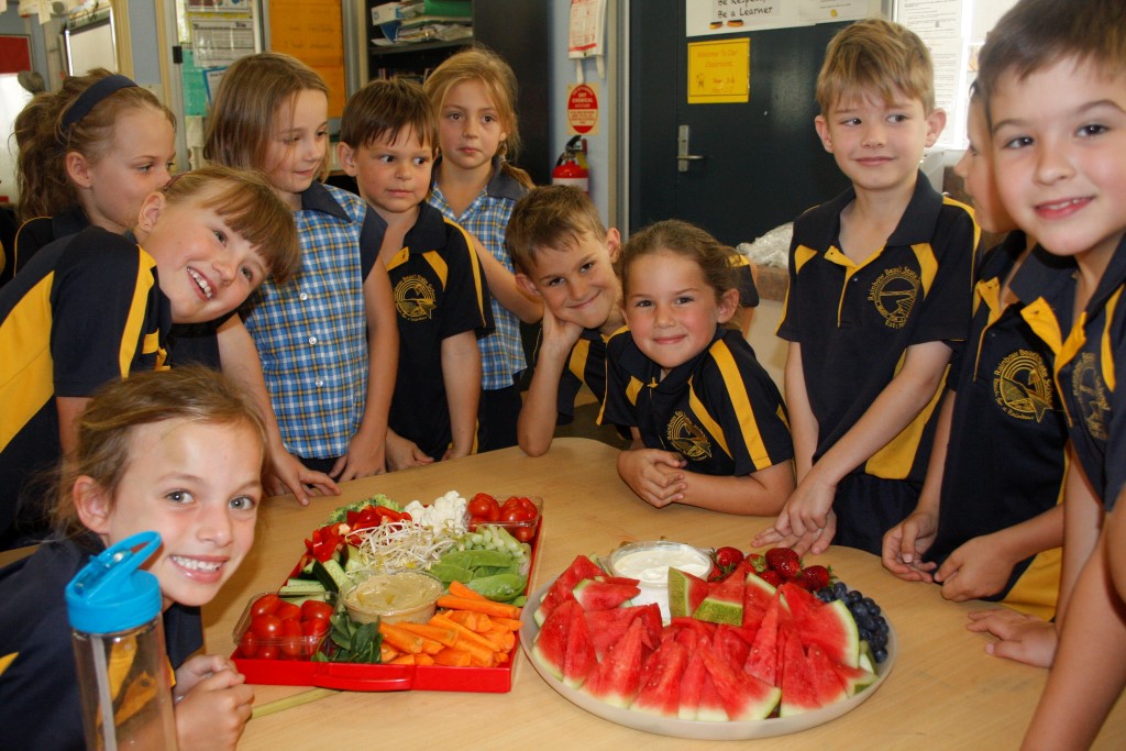 Alex and Zoe Kingsley (seated, centre) were so proud to know that Dad had sent in fruit and veg from Rainbow Fruit to make a delicious platter for their fellow Year 1/2 students