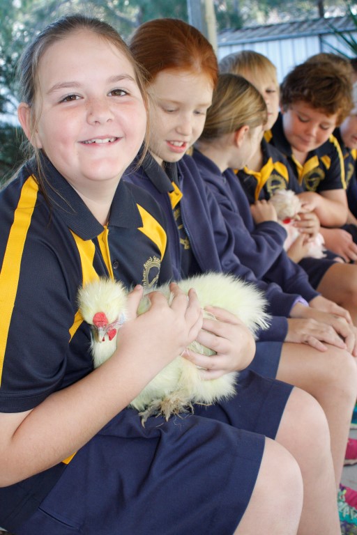 Mikala holding a silky bantam when they visited the kitchen garden
