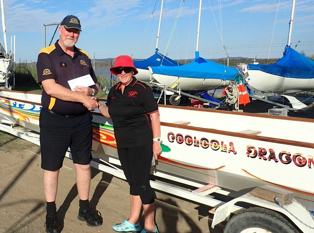 Coastguard representative John MacFarlane receives a donation from President Sandra Wooster