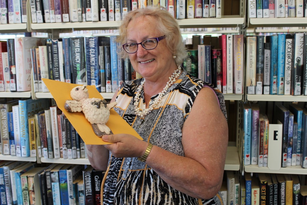 Raewyn Oliver holding the dead parrot, the mascot of the local writer's group
