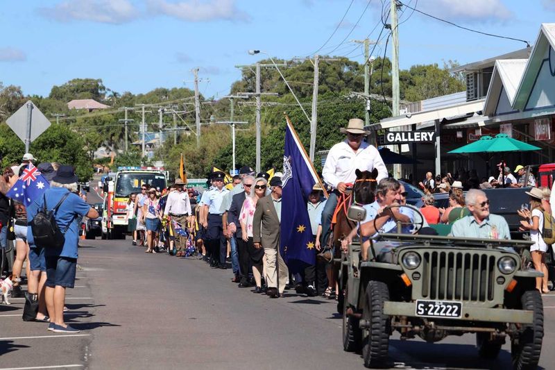 A large crowd waved flags as the Anzac Day March progressed through the main street