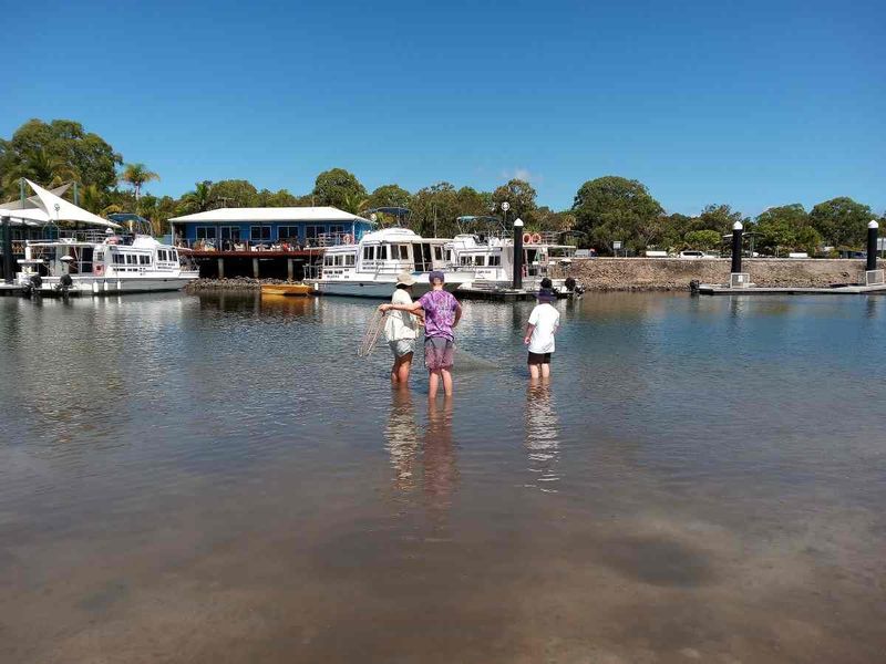 The Rainbow Beach Learning Community kids being taught how to cast a net