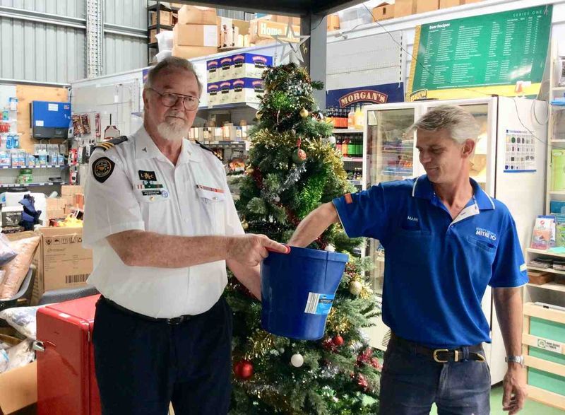 Commander John Macfarlane and Mark from Mitre 10 drawing the Christmas raffle winners for the Tin Can Bay Coastguard