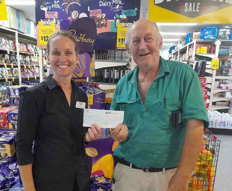 Kristy from Rainbow Beach IGA presenting Tony with a donation cheque