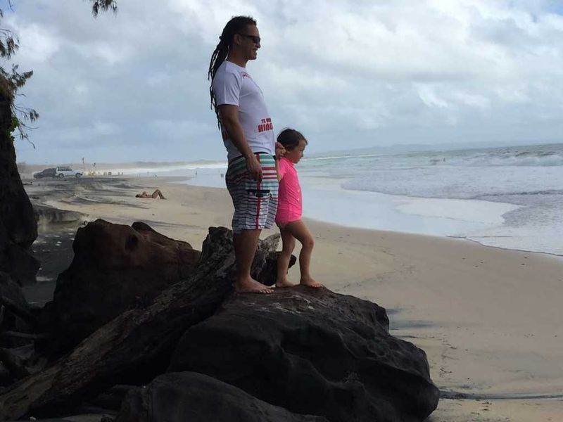 Edwin Hapi and Zia McPherson play on the rocks at Rainbow Beach - just the day before this rock was hardly exposed!