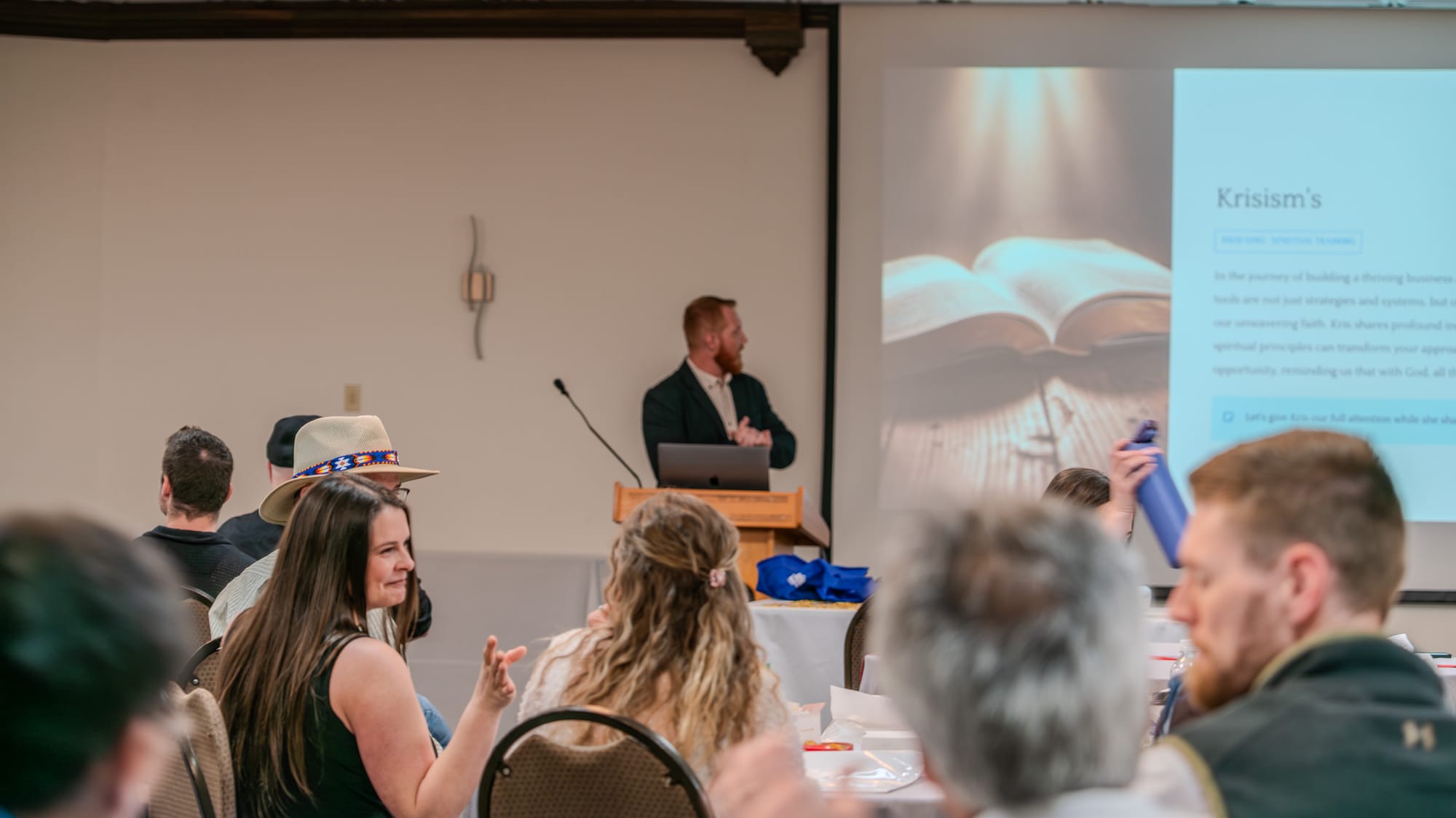 Presenter speaking at the podium during Krisism's segment at Kings of Real Estate Town Hall