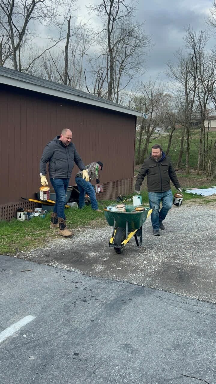 Volunteers hauling supplies with a wheelbarrow