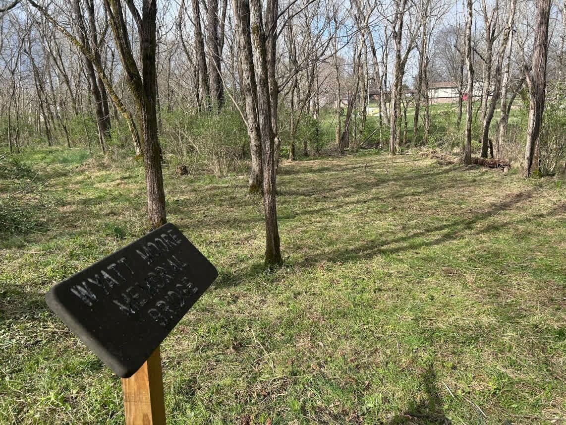 The Wyatt Moore Memorial Bridge sign with freshly cleared grounds