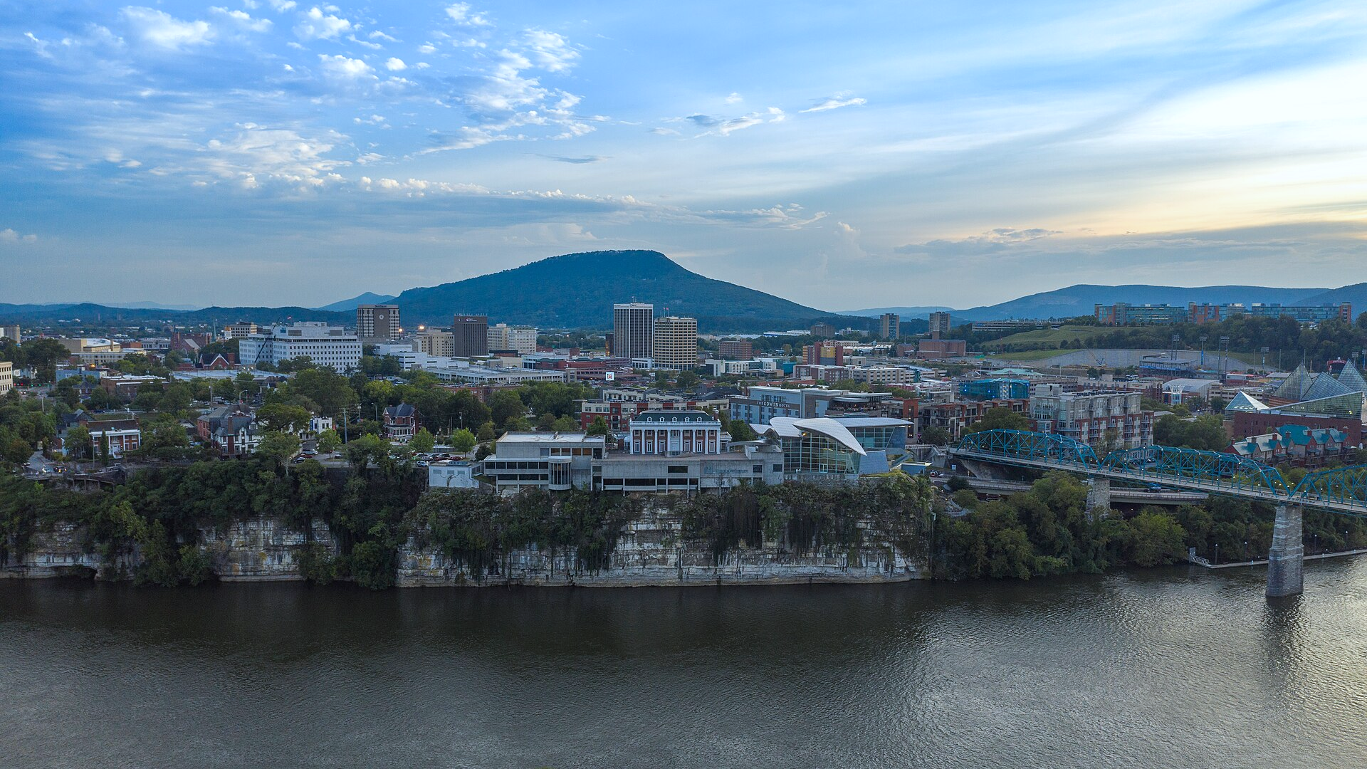 Empty commercial corridor at dusk in East Tennessee with low-rise buildings, trees, and no people, logos, or readable text