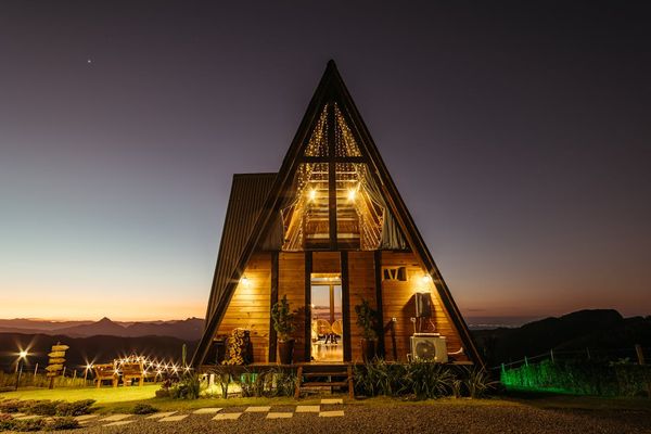 Upscale A-frame cabin at dusk with mountain views — the kind of vacation rental property investors are buying in the Smoky Mountains