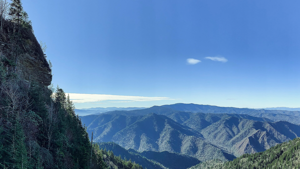 Layered Great Smoky Mountains ridgelines and forested slopes under a clear blue sky, with no people, logos, or text