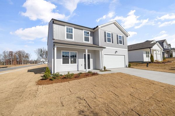 Elegant two-story house in a quiet suburban neighborhood under a blue sky.