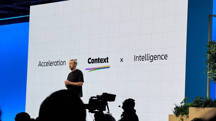 Acceleration equals context times intelligence on a screen with the CEO of Atlassian in front