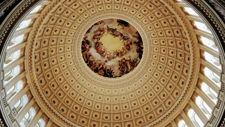The ornate dome of the U.S. Capitol, with a fresco of George Washington ascending among gods—a modern temple to power and divine ambition.