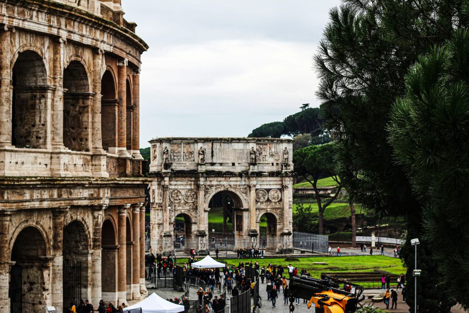 Rome’s Colosseum and Arch of Constantine stand worn but enduring, framed by green grass and modern life—a living echo of empire amid the present.