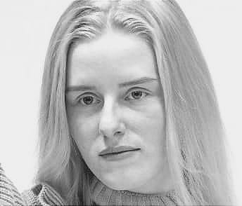 A woman looking straight ahead without obvious facial expression. An example of what many call the Gen Z stare.