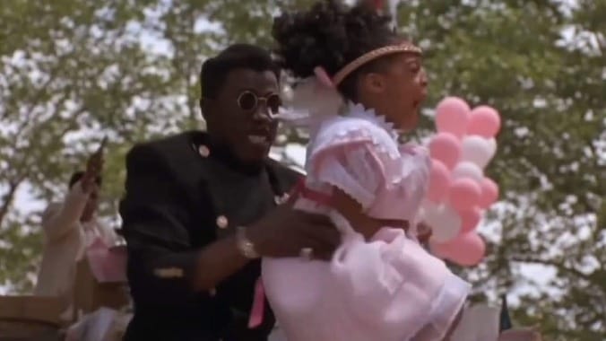 Still from New Jack City showing Nino Brown holding a young girl in front of him during a shooting, used here as a metaphor for scapegoat roles and organizational human shields.