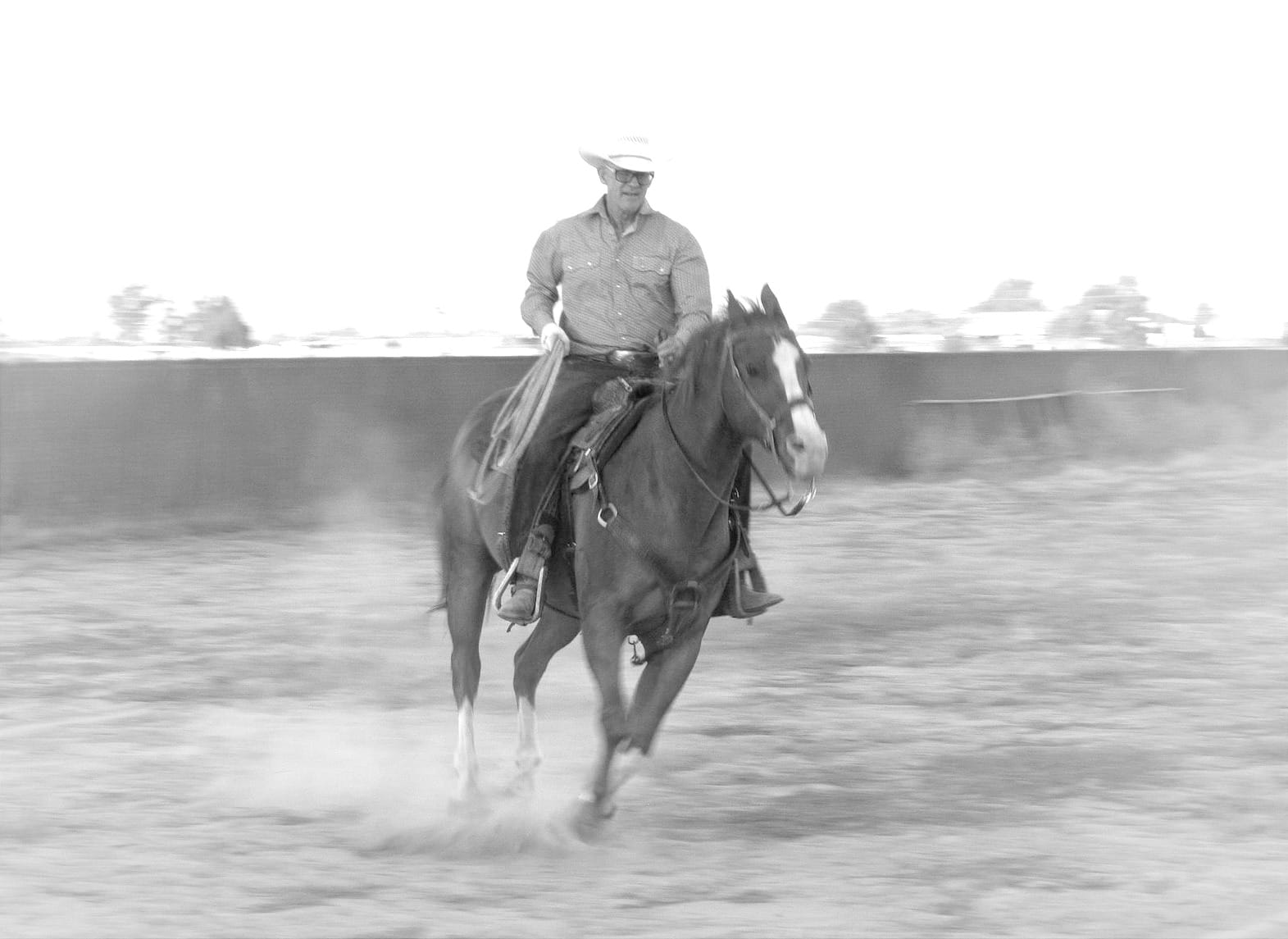 A man in a white cowboy hat riding on the back of a brown horse