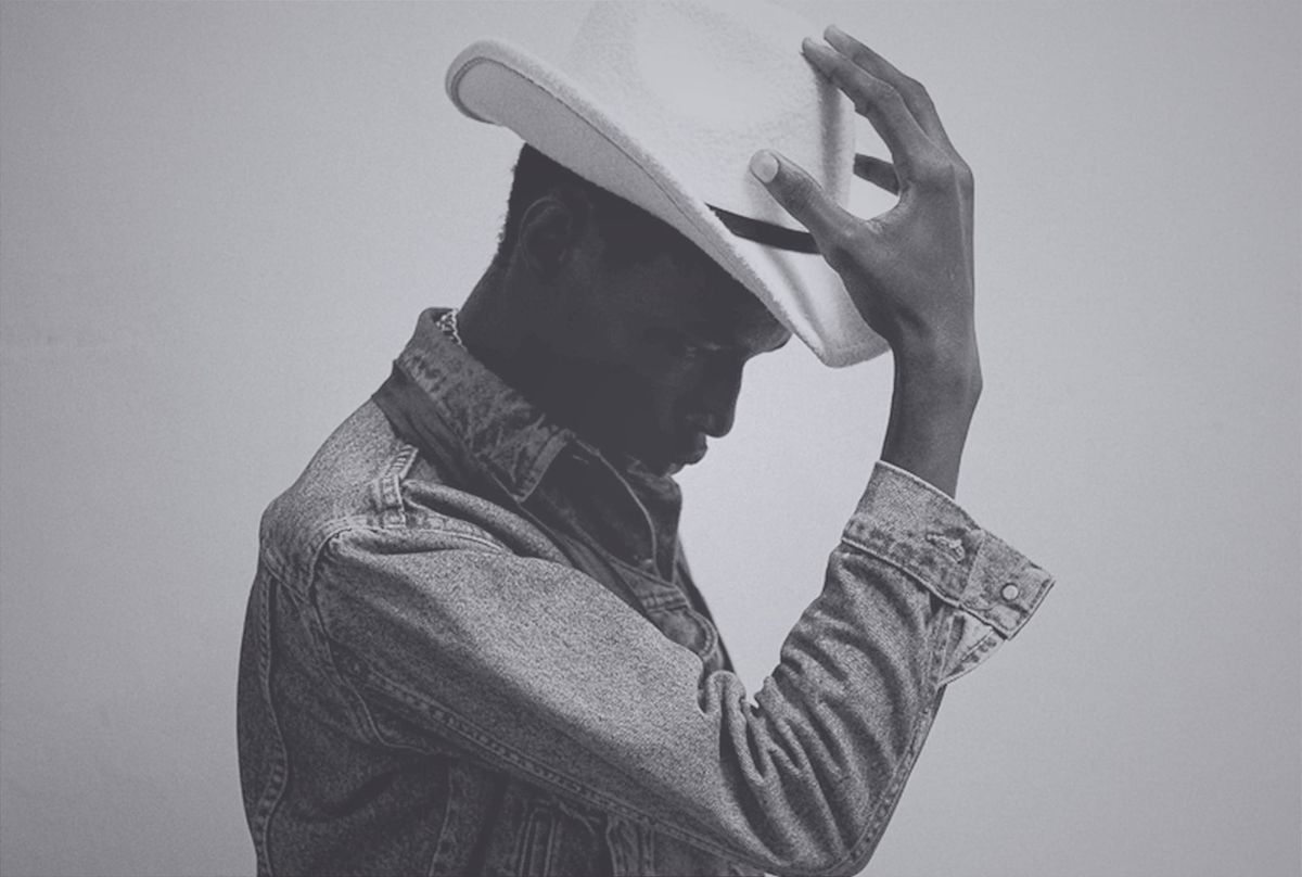 Black-and-white photo of a Black man in a denim shirt tipping a white cowboy hat, used as a metaphor for hero identity and visible rescue.
