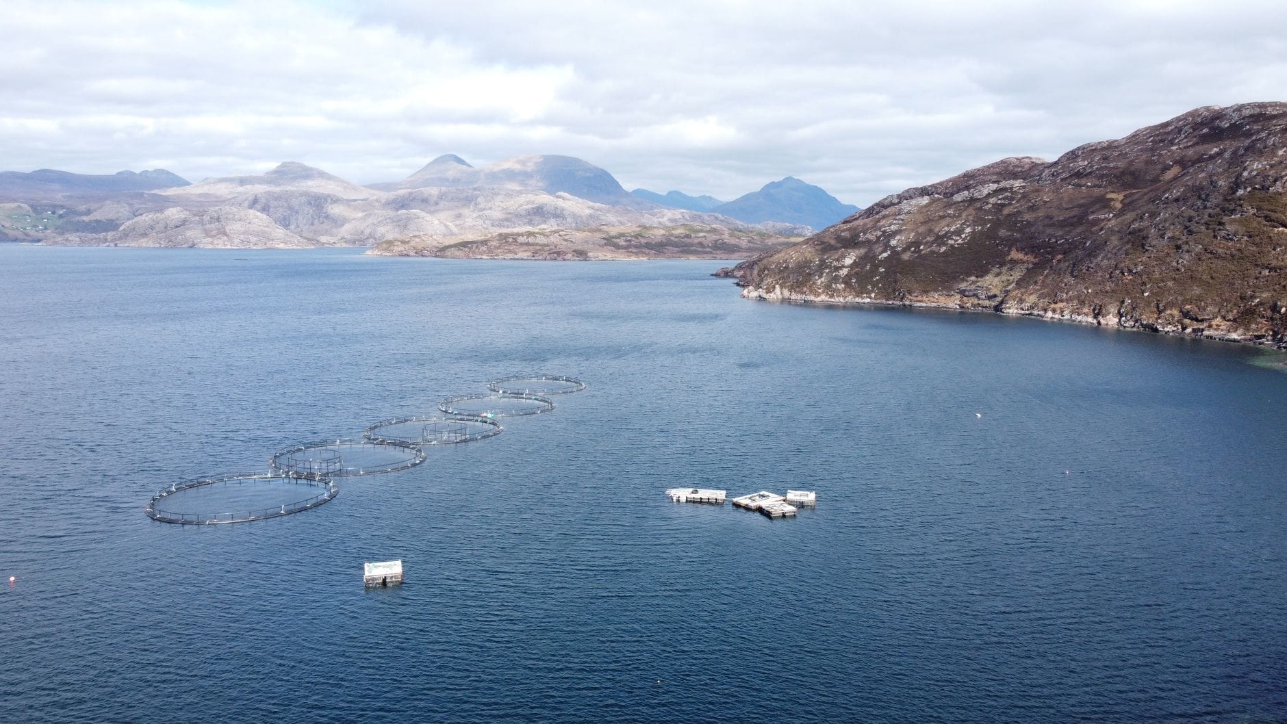 Aerial photograph of a fish farm in a loch in Scotland, showcasing stunning landscapes.