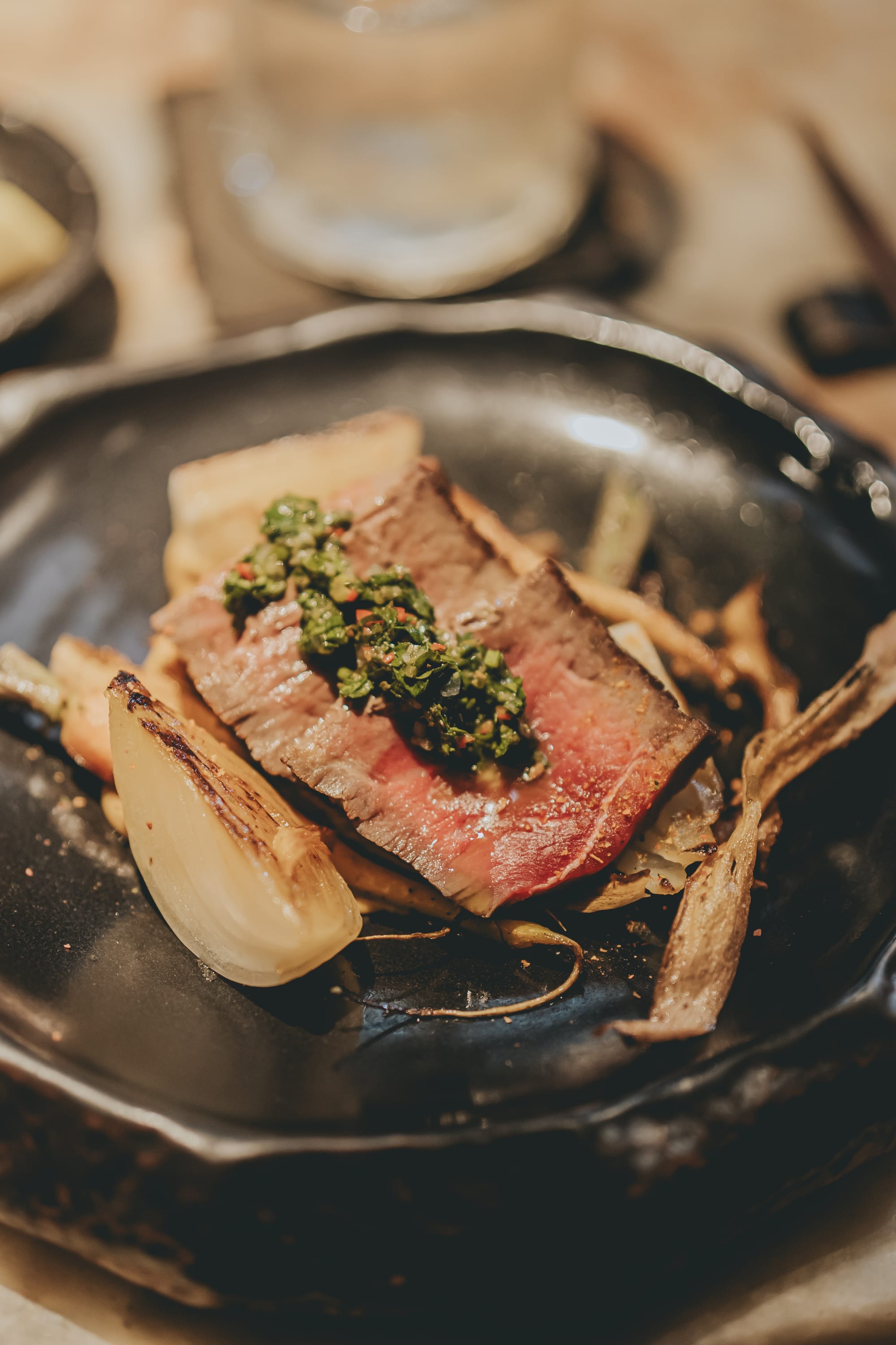 Chef Carlos Barvo carving and torching a tomahawk steak at the Miss Fish omakase counter during MATSURI 2026 in Canggu