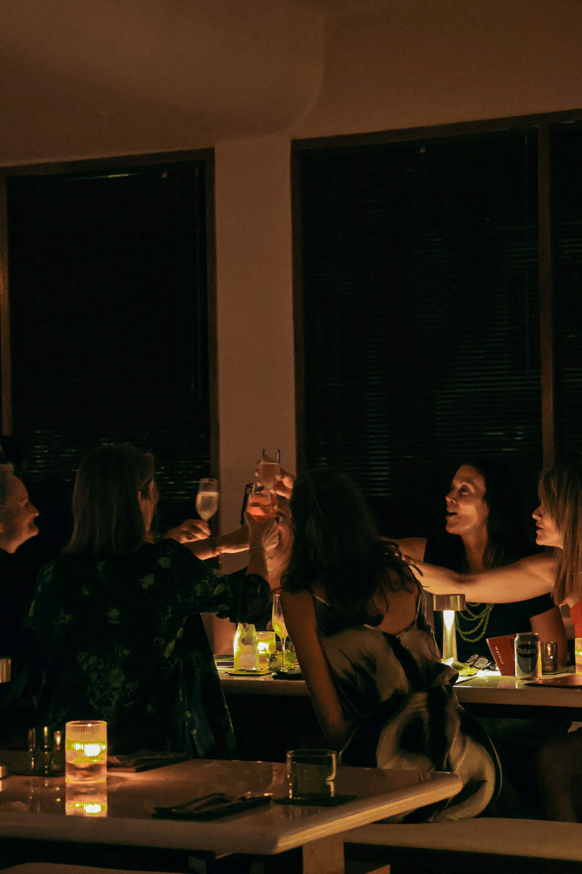 Guests laughing over cocktails and wine inside the new nüde Berawa dinner venue in Canggu, Bali.