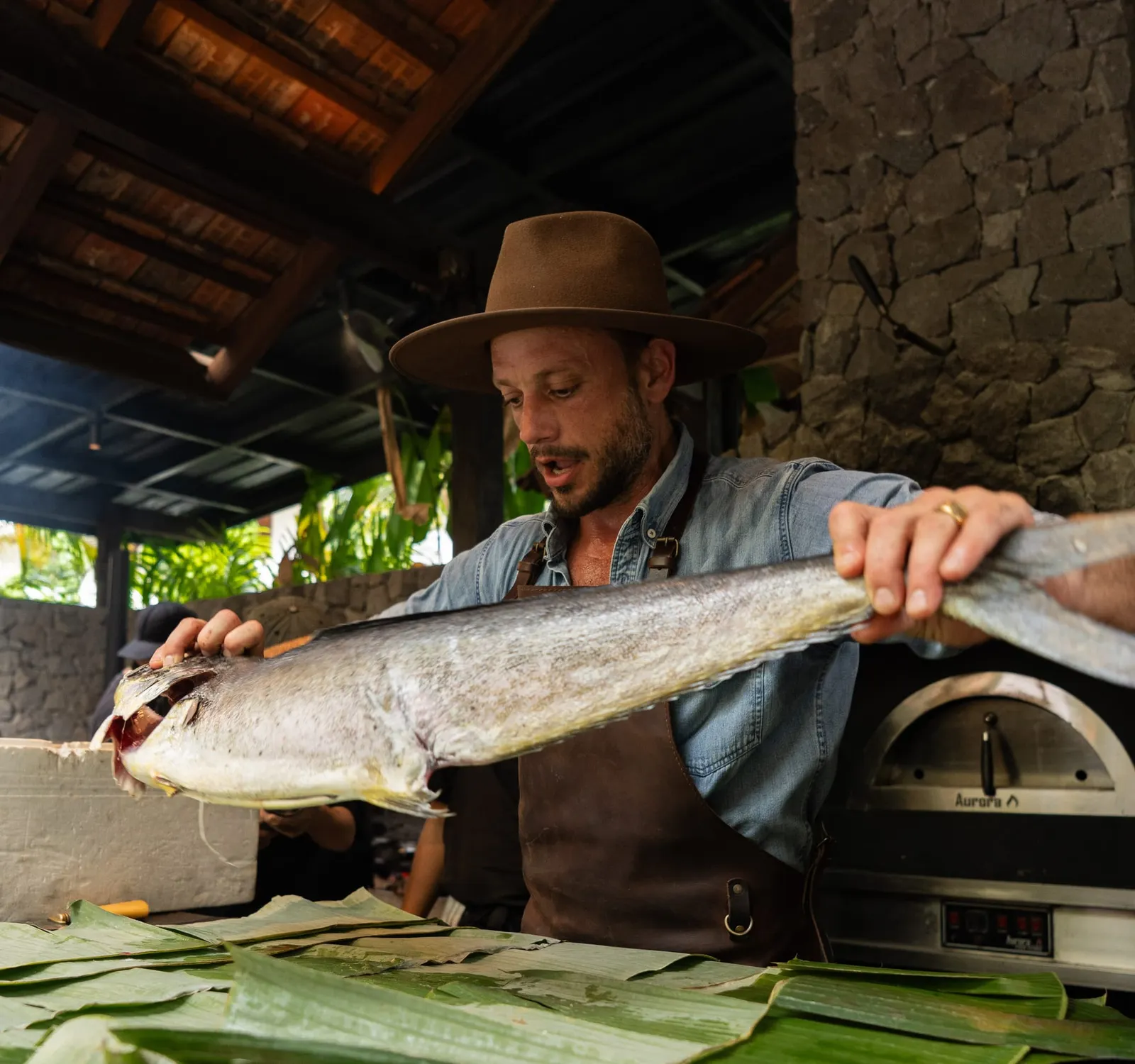 Charly Pretet of Terra Firma Dining preparing a whole fish over an open wood fire