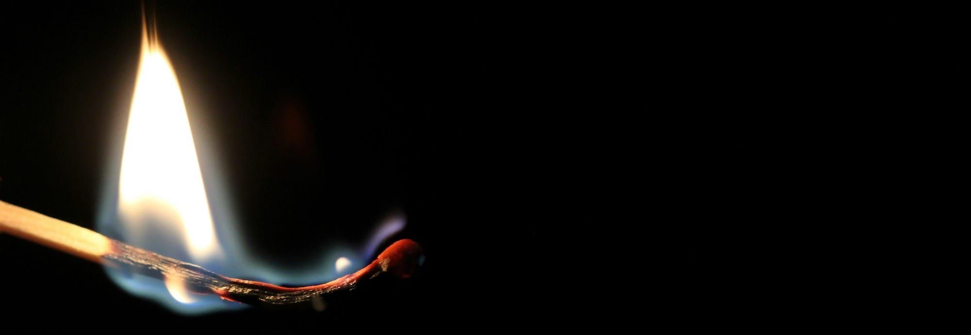 A match, almost burned completely, starting to curl. 