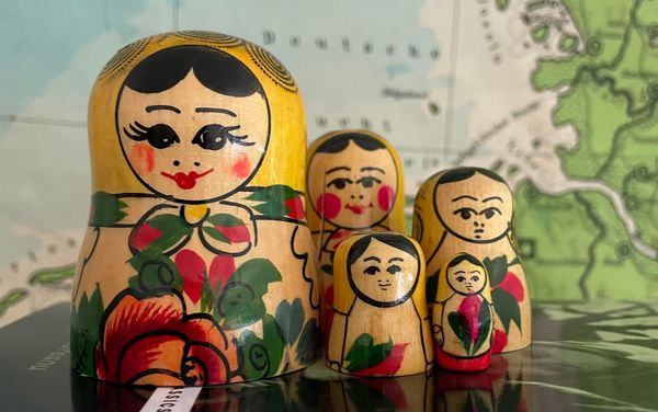 Unstacked Russian dolls in front of a map