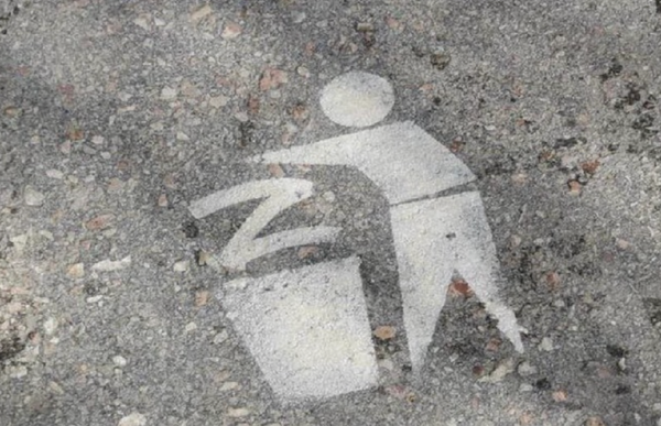 spray-painted figured dropping a "Z" (symbol of Putin's invaders) in a waste bin