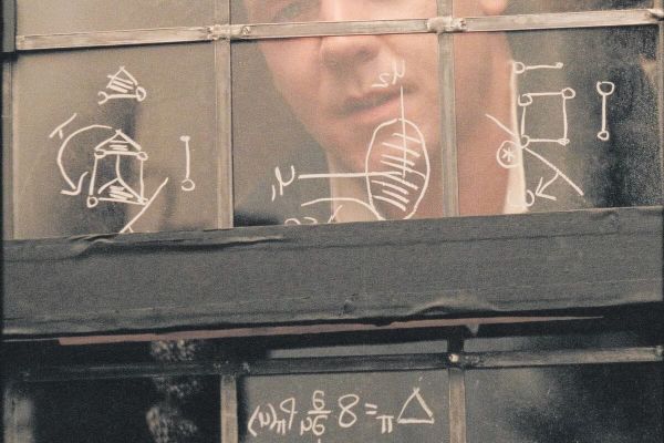 Image of Russell Crowe in the movie A Beautiful Mind where he is writing exotic math equations on a window.
