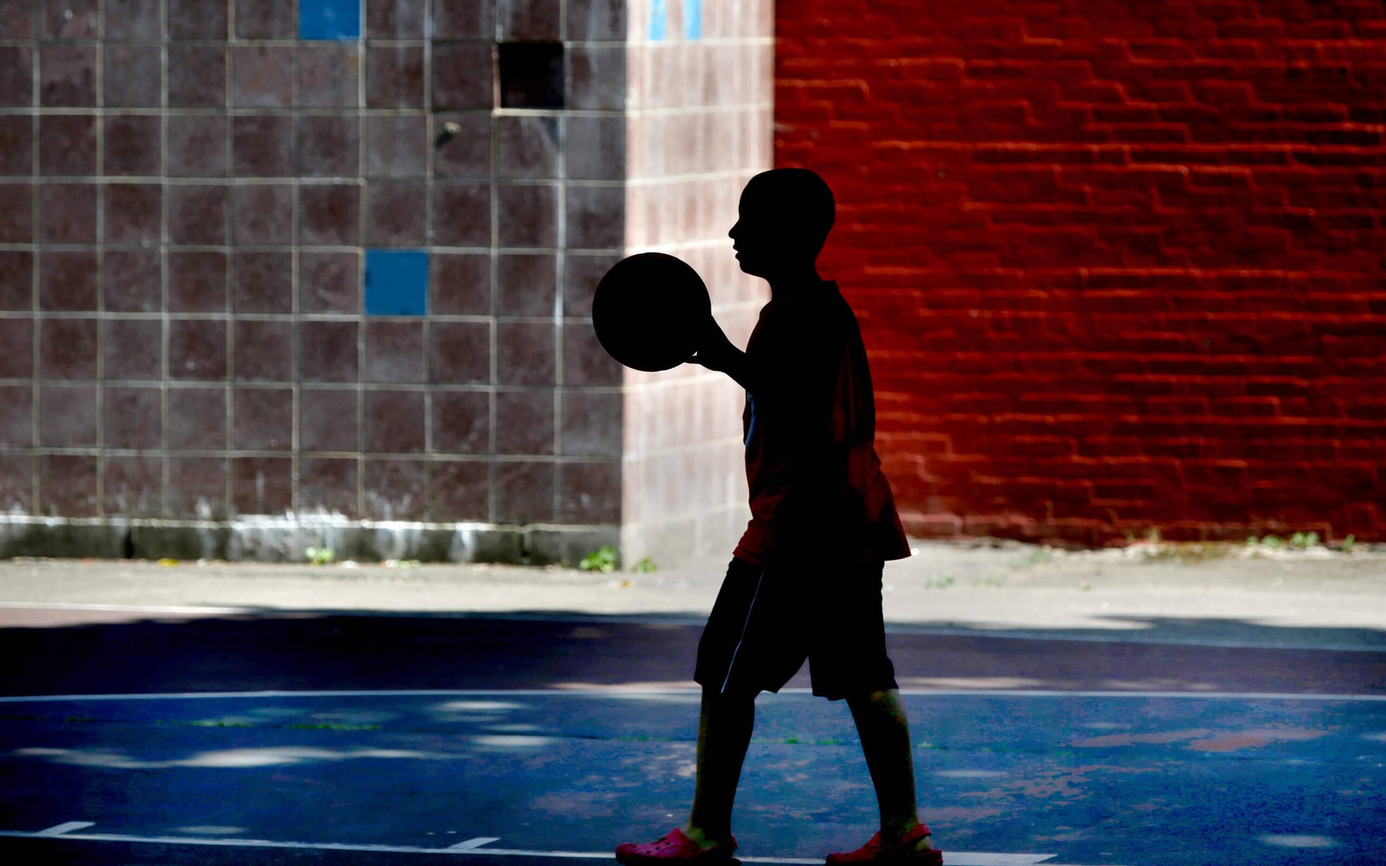  Un jugador de baloncesto tira al aro en un día caluroso en el O'Day Playground en el vecindario South End de Boston. (Jonathan Wiggs/The Boston Globe vía Getty Images)
