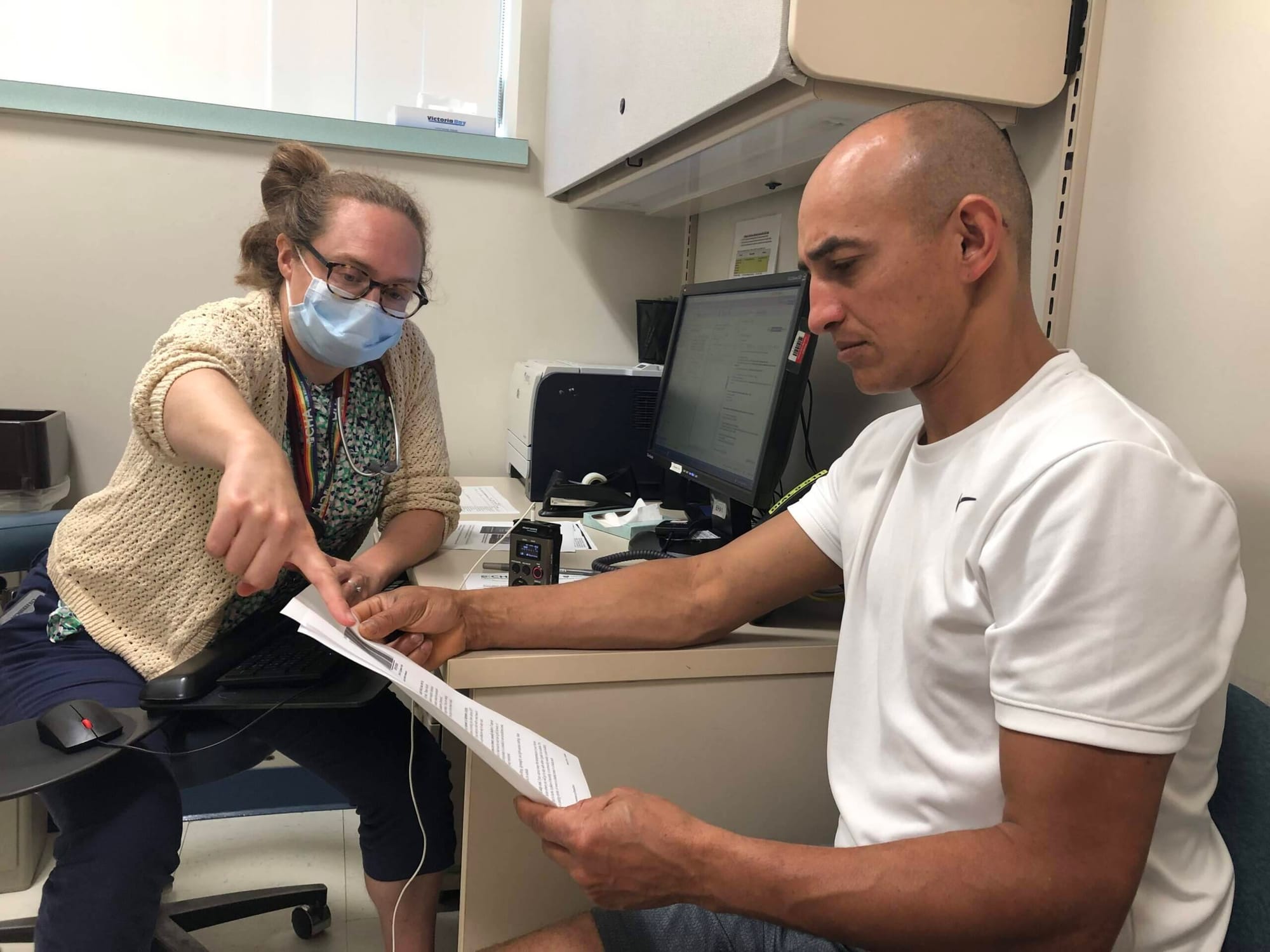  La Dra. Rebecca Rogers destaca consejos de hidratación para Luciano Gomes, que trabaja en la construcción. (Martha Bebinger/WBUR)

