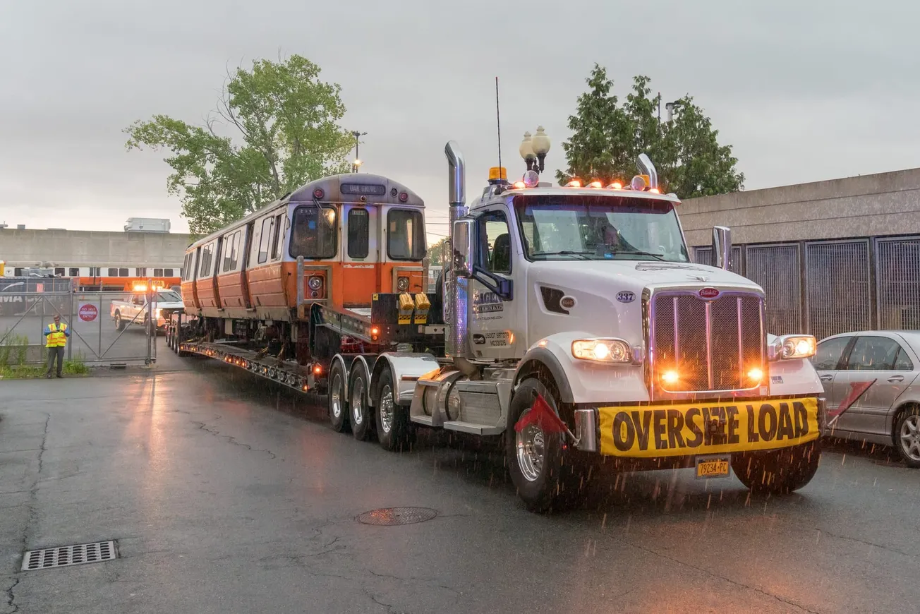 En medio de un torrencial aguacero, la MBTA comenzó el traslado de los trenes viejos de la Línea Naranja al deshuesadero para
