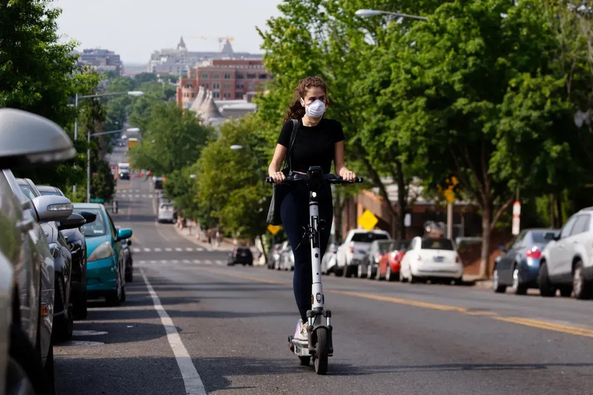 Una persona lleva una máscara respiratoria mientras conduce un scooter en Washington, DC, EE.UU., 09 de junio 2023. La calida