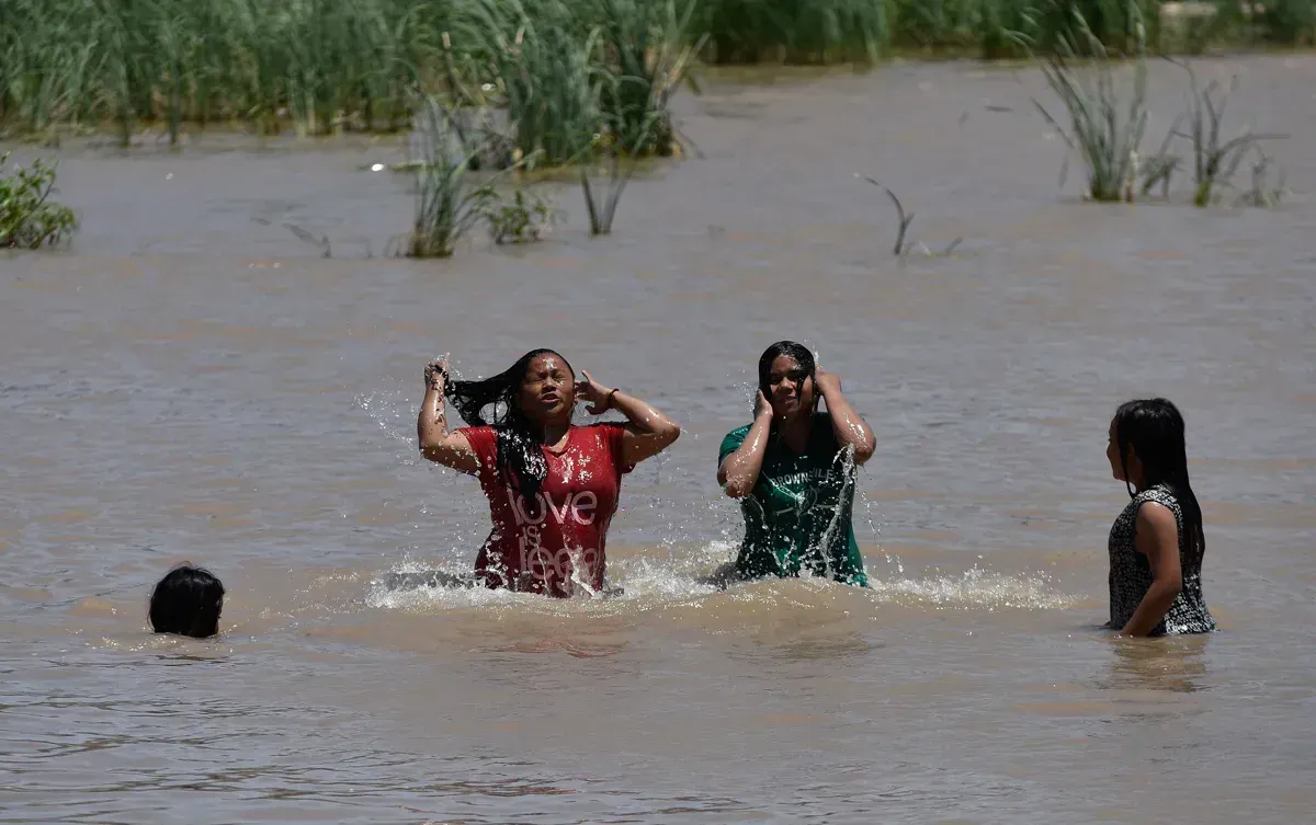 Personas se bañan en el agua del río Bravo, hoy, en Ciudad Juárez (México). La atípica ola de calor en la frontera norte de M