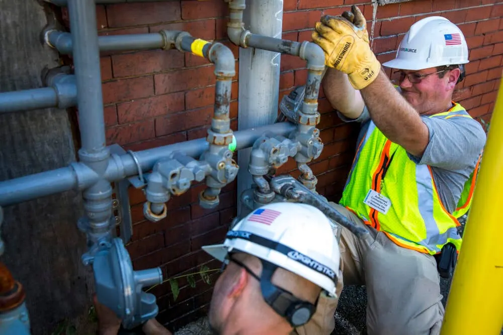 Trabajadores de Eversource reparan tuberías de gas en un edificio en Lawrence. (Foto de Nic Antaya para The Boston Globe vía