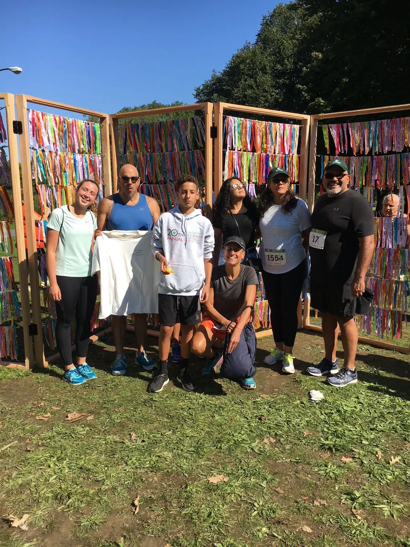 Rubén Azocar con familiares y amigos parados frente a la pared de la cinta del recuerdo. Cada año, los participantes de la ca