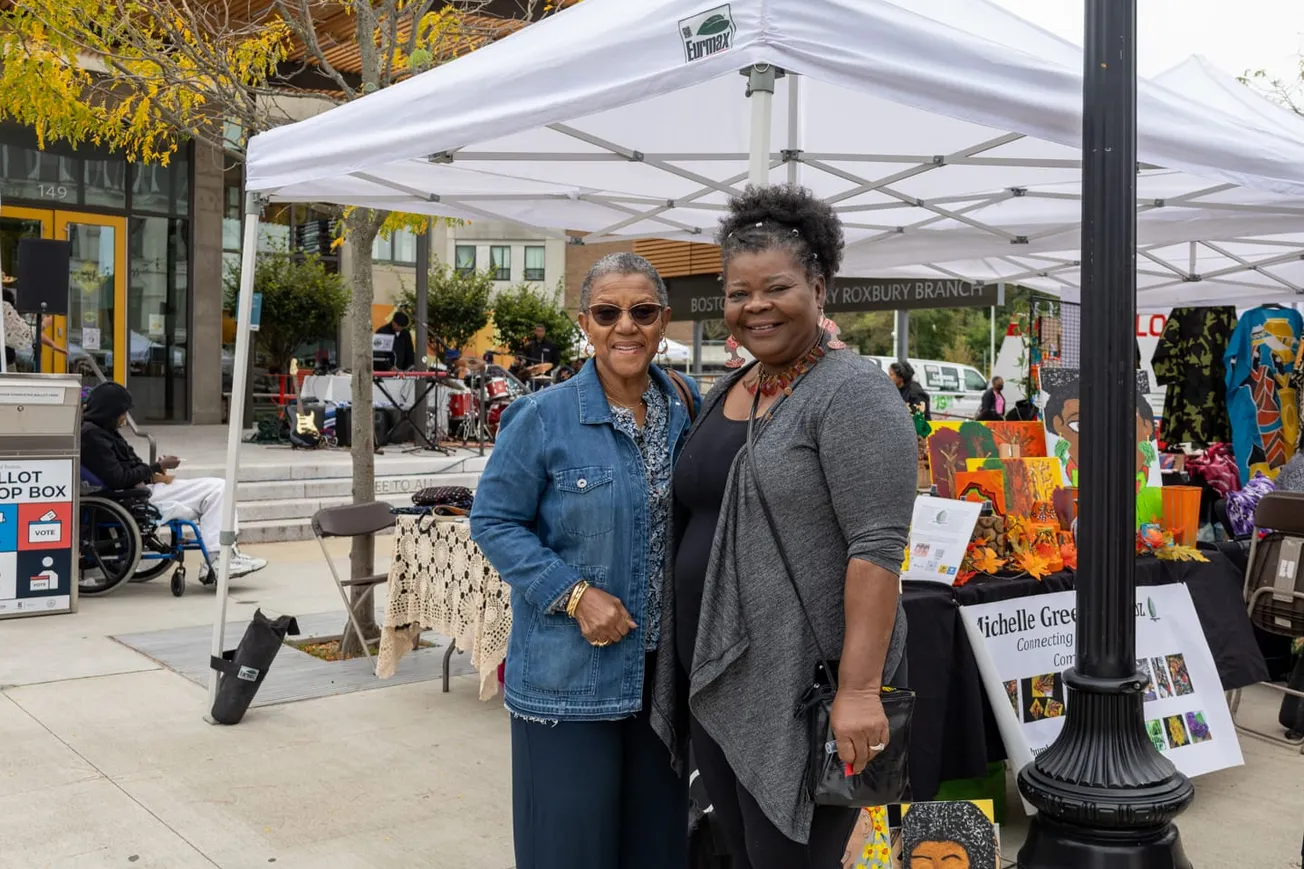Michelle Carter (derecha) y Diane Davis (izquierda) posan juntas en el evento Savor the Square fuera de la sucursal de Roxbur