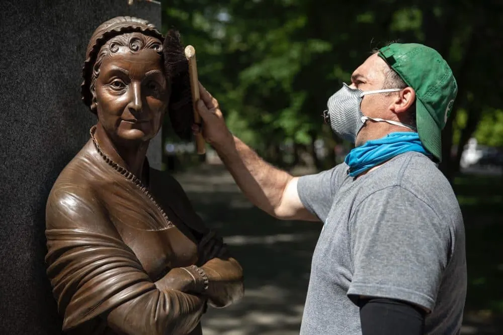 El conservador de esculturas Joshua Craine finaliza la limpieza de la estatua de Abigail Adams en el Memorial de Mujeres de B