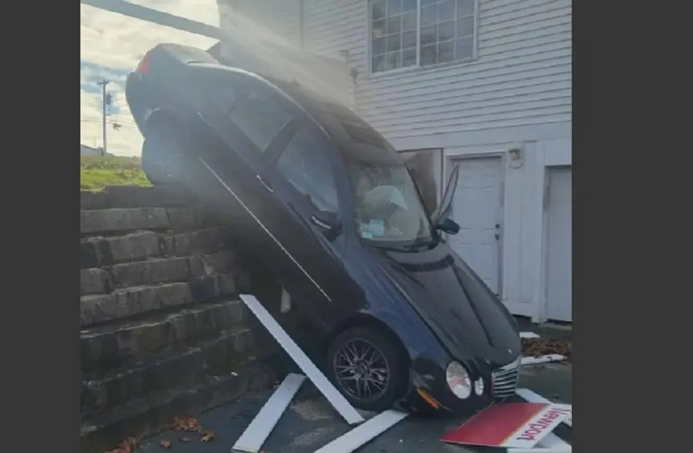 Un auto se deslizó por un terraplén y terminó cayendo en la entrada de una vivienda