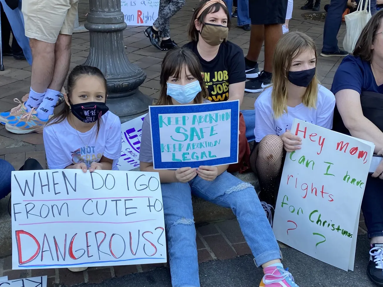 Marcha de las Mujeres en el 2021 en DC. Los letreros resaltan mensajes como: "Hola mamá, ¿puedo tener derechos para Navidad?"